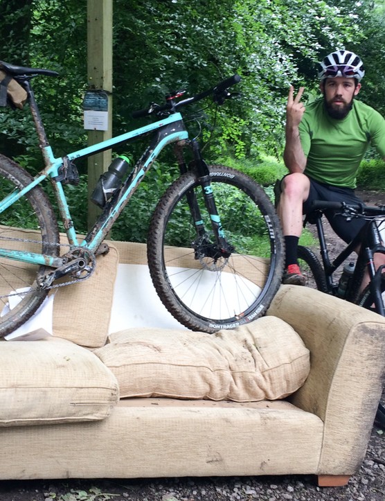 Bicicleta de montaña hightail y jinete masculino en el sofá